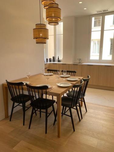 - une table à manger, des chaises et des verres à vin dans l'établissement Appartement refait à neuf au coeur de Nice, à Nice