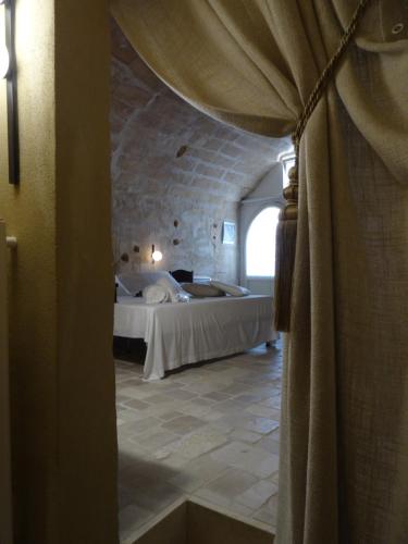 a bedroom with a bed and a large window at LA DIMORA DELLE 3 ZIE in Matera