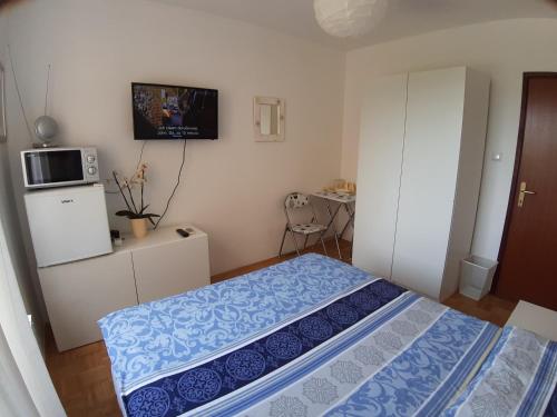 1 dormitorio con 1 cama y TV en la pared en Rooms Vukovarska, en Zagreb