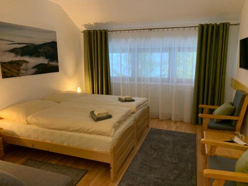 a bedroom with a bed and a large window at Penzión Solisko*** Oščadnica in Oščadnica