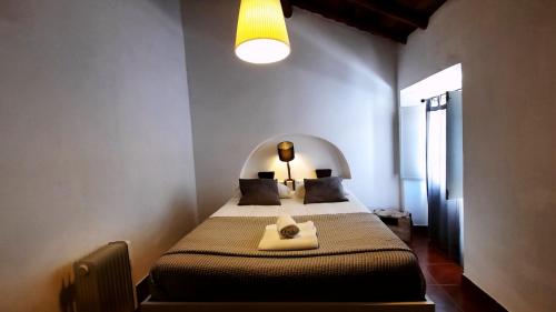 een slaapkamer met een bed in een kamer met een licht bij Casa do Lêntejo - Casas de Taipa in São Pedro do Corval