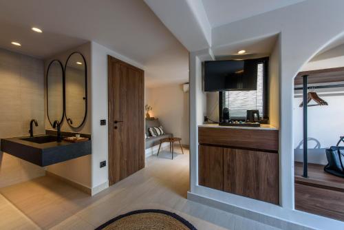 een badkamer met een wastafel en een spiegel bij Soleil Rooms and Suites in Stalida