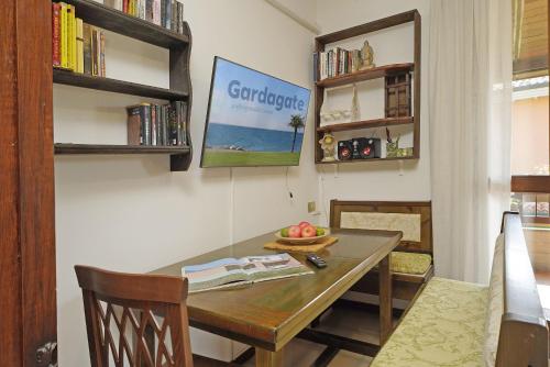 una sala da pranzo con tavolo e libreria di Appartamento Balander - Gardagate a Sirmione