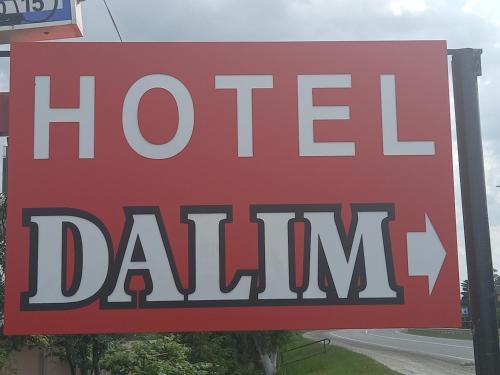 a red sign for a hotel dahim on a street at DALIM in Duliby