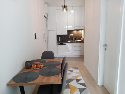 une cuisine et une salle à manger avec une table et des chaises en bois dans l'établissement Apartman Bijela Bjelašnica, à Bjelašnica