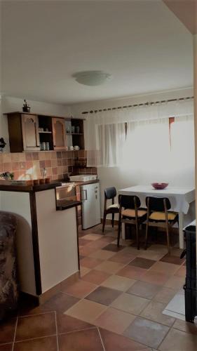 a kitchen with a table and chairs in a room at Kuća za odmor VB-IDRO in Tuhelj