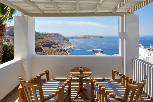 a balcony with chairs and a view of the ocean at Volcano View by Caldera Collection in Fira