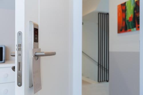 a white refrigerator with a door with a tag on it at The Old Town Boutique Hotel - Adults Recommended in Estepona