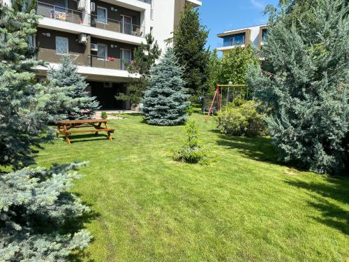 a park with a bench and trees in a yard at Bucharest Airport Suites & Villas in Otopeni