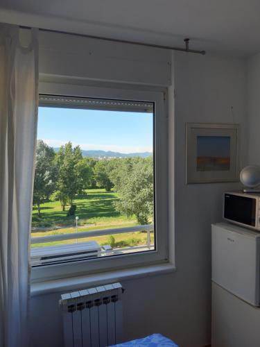 uma janela num quarto com vista para um campo em Rooms Vukovarska em Zagreb