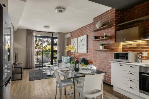 a kitchen and dining room with a table with chairs at Easy Stay - The Vantage Rosebank in Johannesburg