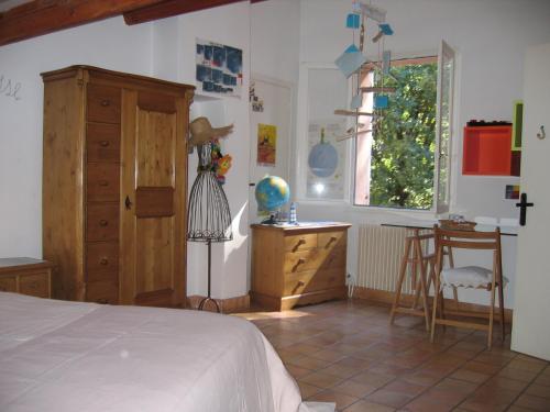 une chambre avec un lit, un bureau et une fenêtre dans l'établissement Maison Proche d'Aix-en-Provence, à Peynier