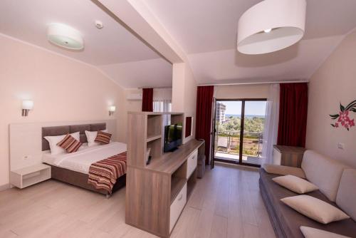 1 dormitorio con cama, sofá y TV en Vila Iulia en Mamaia-Sat
