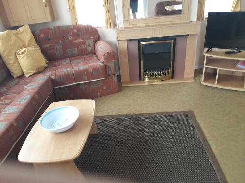 a living room with a couch and a fire place at TP52 in Skegness