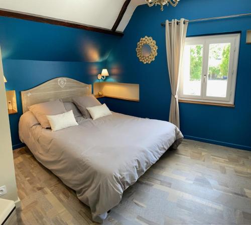 Dormitorio azul con cama y ventana en LA MAISON DE TRIBOULET Chambres et table d'hôtes -Amboise-, en Pocé-sur-Cisse