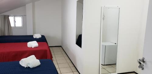 a room with two beds and a door with towels at LIVE IN FORTALEZA HOTEL in Fortaleza