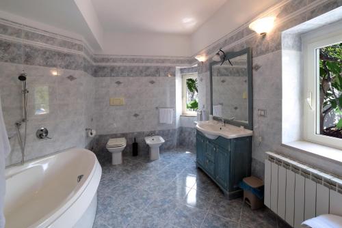 y baño con bañera, aseo y lavamanos. en B&B Bella Peschici, en Peschici