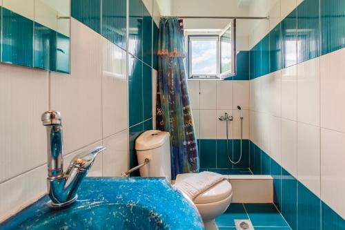 a bathroom with a blue sink and a toilet at Villa Stymfalia - Luxury Mansion with Private Pool in Kartérion