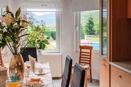 a kitchen and dining room with a table with a vase at Villa Stymfalia - Luxury Mansion with Private Pool in Kartérion