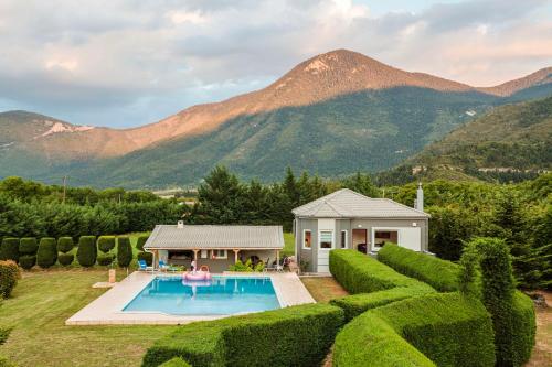 a house with a swimming pool and mountains in the background at Villa Stymfalia - Luxury Mansion with Private Pool in Kartérion
