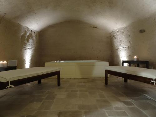 a room with two benches and a bath tub at LA DIMORA DELLE 3 ZIE in Matera