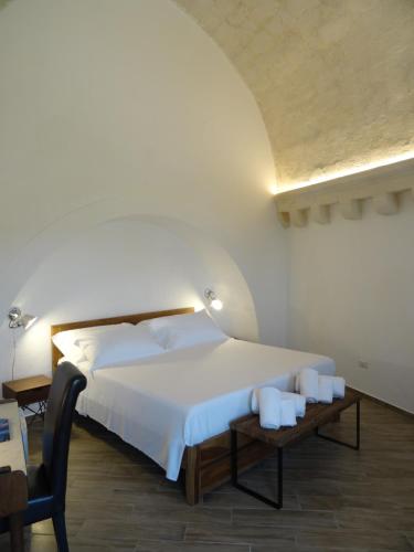 a bedroom with a bed and a table with towels at LA DIMORA DELLE 3 ZIE in Matera