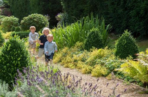 two children walking through a garden with flowers at Four Seasons Hotel Hampshire in Winchfield