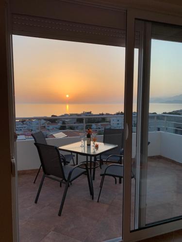 d'une table et de chaises sur un balcon avec vue sur le coucher du soleil. dans l'établissement Apartman Joja, à Bar