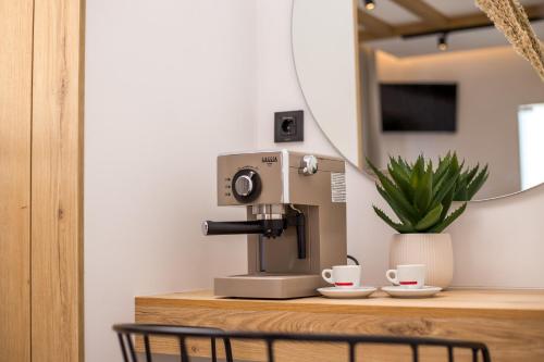 una macchina da caffè seduta su un bancone con due tazze di cactus suites a Faliraki