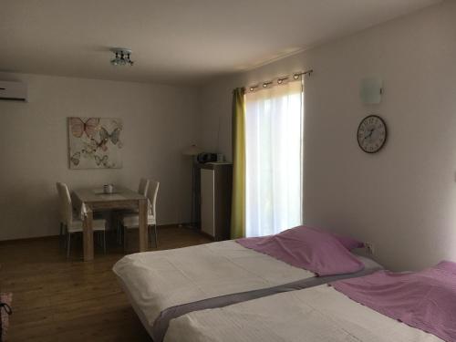 a bedroom with a bed and a table and a window at Apartment Vista in Lupoglav