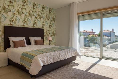AmoreiraにあるVilla do Golf 9のベッドルーム(大型ベッド1台、大きな窓付)