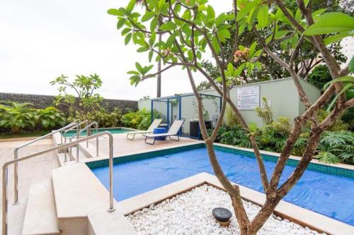 a villa with a swimming pool and a tree at Flat The Expression 1210 in Goiânia