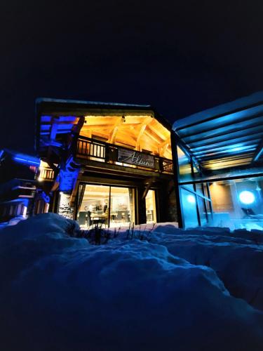 a building in the snow at night with blue lights at Hotel Alpina in Morzine