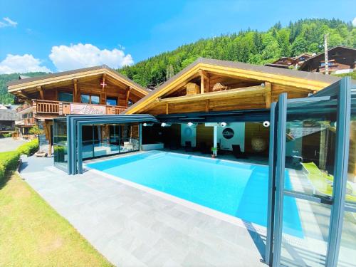 a house with a swimming pool in front of it at Hotel Alpina in Morzine