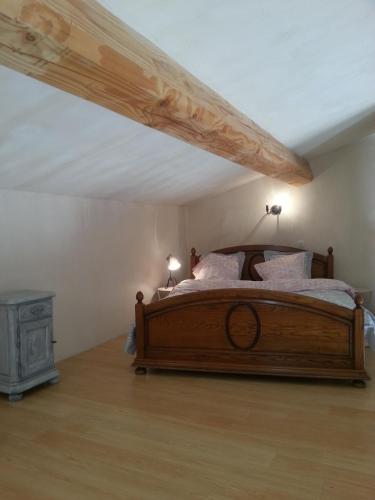 - une chambre mansardée avec un lit en bois dans l'établissement Sympathique Maison au Soleil & Whirlpool Privé dans Quartier Calme !, à Entrecasteaux