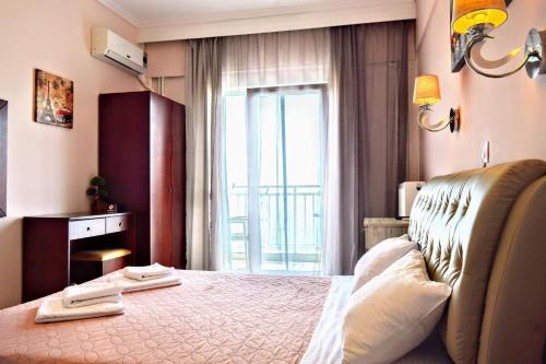 - une chambre avec un grand lit et une fenêtre dans l'établissement Olympic Hotel, à Olympiada