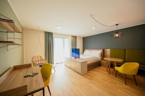 une chambre d'hôtel avec un lit, une table et des chaises dans l'établissement Rioca Vienna Posto 1, à Vienne