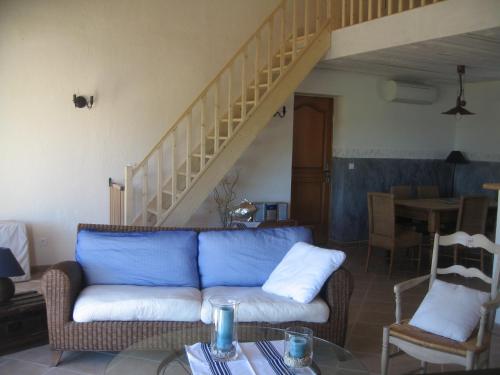 a living room with a blue couch and a staircase at Grande Maison Mitoyenne & Spa à Bulles au Soleil dans Quartier Calme ! in Entrecasteaux