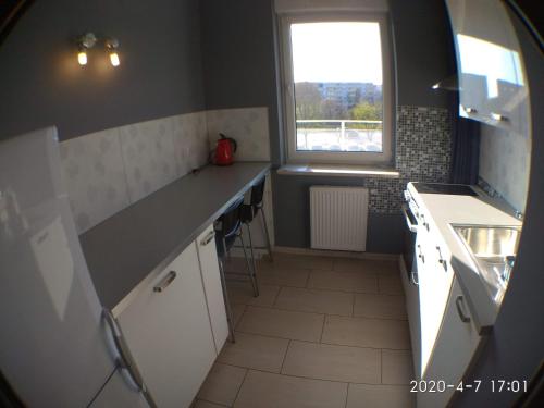 una pequeña cocina con fregadero y ventana en 1090 Śmiałego 38 - Tanie Pokoje w Apartamencie - samodzielne zameldowanie - self check in, en Poznan