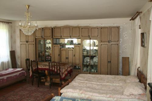 a bedroom with a bed and a table and a chandelier at Guest House Nazy in Stepantsminda