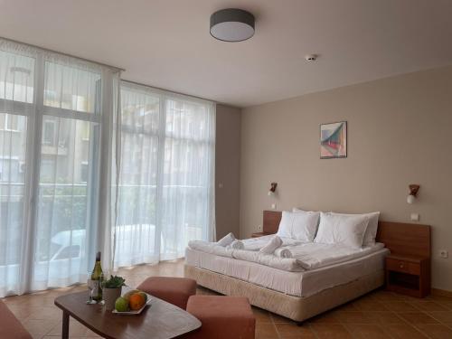 a living room with a large white couch in front of windows at Hotel ECO Palace in Primorsko
