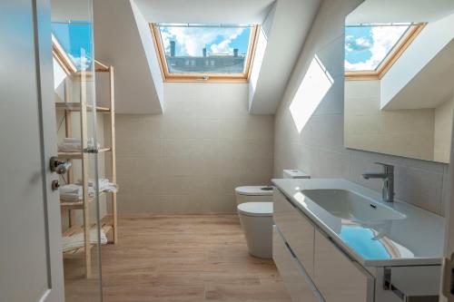 a bathroom with a sink and a toilet with skylights at Casa Rural San Victorian 16 in Aínsa