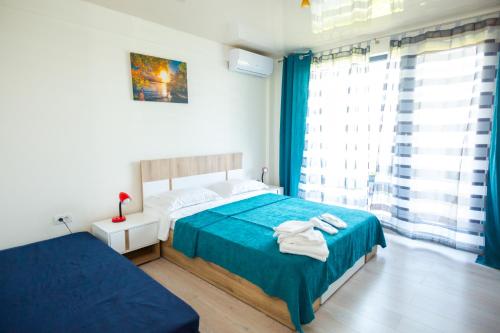 a bedroom with a blue bed and a window at Casa Angy in Techirghiol