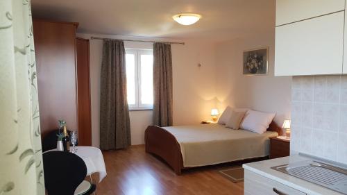 a small room with a bed and a window at Apartmani Diva in Malinska