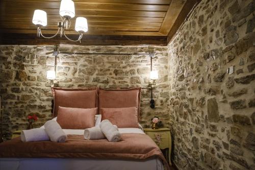 1 dormitorio con paredes de piedra y 1 cama con 2 almohadas en Guest House Anthrakitis, en Zagori