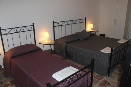 een slaapkamer met 2 bedden en 2 tafels en 2 lampen bij Casa Giulia in Pisa