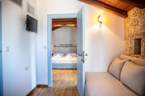 a room with a bed and a door leading to a bedroom at Trapela Areopolis, Boutique Hotel in Areopolis