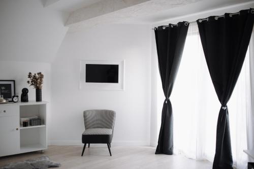 sala de estar con cortinas negras y silla en The Corner50 en Alba Iulia