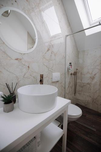 a white bathroom with a sink and a toilet at The Corner50 in Alba Iulia