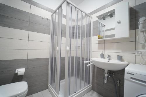 La salle de bains est pourvue d'une douche, de toilettes et d'un lavabo. dans l'établissement Lucrezia Suites - Apartment, à Cariati